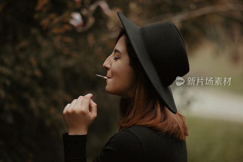 Young redhead woman portrait smoking cigarette and smiling with eyes closed